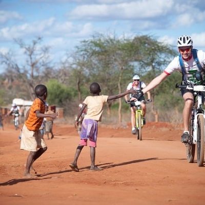 Africa-Classic-Uganda-Tanzania-kids-with-mountainbiker-happy-kids-high-five-MultidayMTB